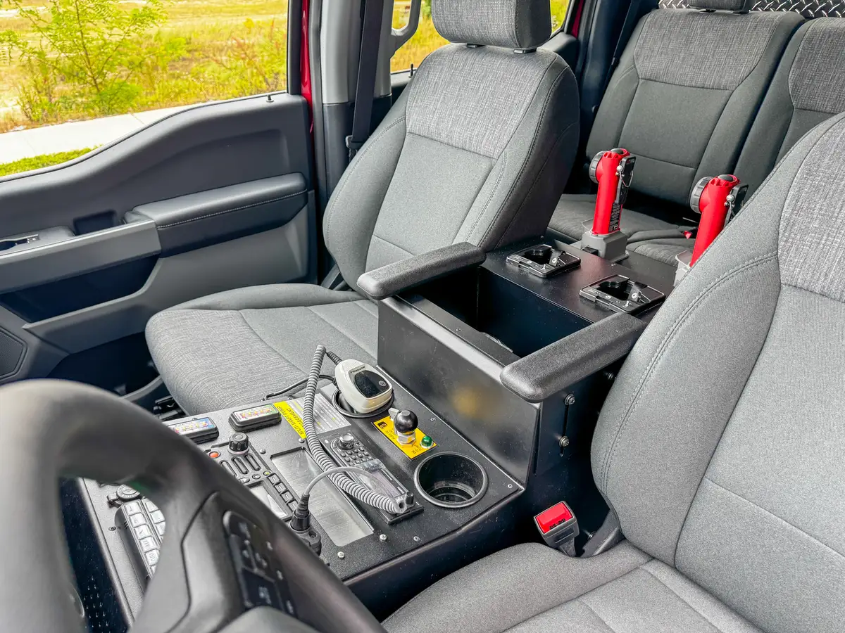 Under-seat area close-up with fluid-data label and illuminated indicator light.